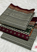 Three folded pieces of patterned fabric arranged on a white faux-fur surface. The fabrics feature black, beige, and burgundy geometric and striped patterns, with one piece showing a small green accent stripe.