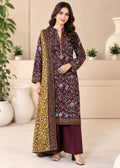 A woman modeling a traditional three-piece salwar kameez suit. The outfit features a deep maroon kurta with intricate blue and white floral embroidery, a matching maroon trouser, and a mustard yellow dupatta with a detailed border print.