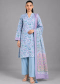 A woman modeling a light blue floral printed kurta set with matching light blue pants and a lavender-purple patterned dupatta, photographed against a solid gray studio background.