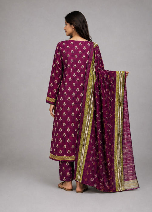 A woman modeling a traditional three-piece salwar kameez suit in deep magenta with gold and white motifs, shown from the back against a neutral gray studio background.