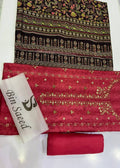 A folded and flat-laid traditional Indian salwar suit material set on a white surface, featuring a dark brown printed upper fabric, a bright pink lower fabric with gold embroidery, a matching pink rolled fabric piece, and a white branded tag reading 'Bin Saeed'.