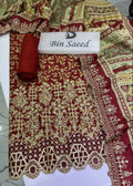 A traditional embroidered fabric set in deep red, featuring intricate gold and beige floral patterns, a matching rolled fabric piece, and a white label reading 'Bin Saeed'.