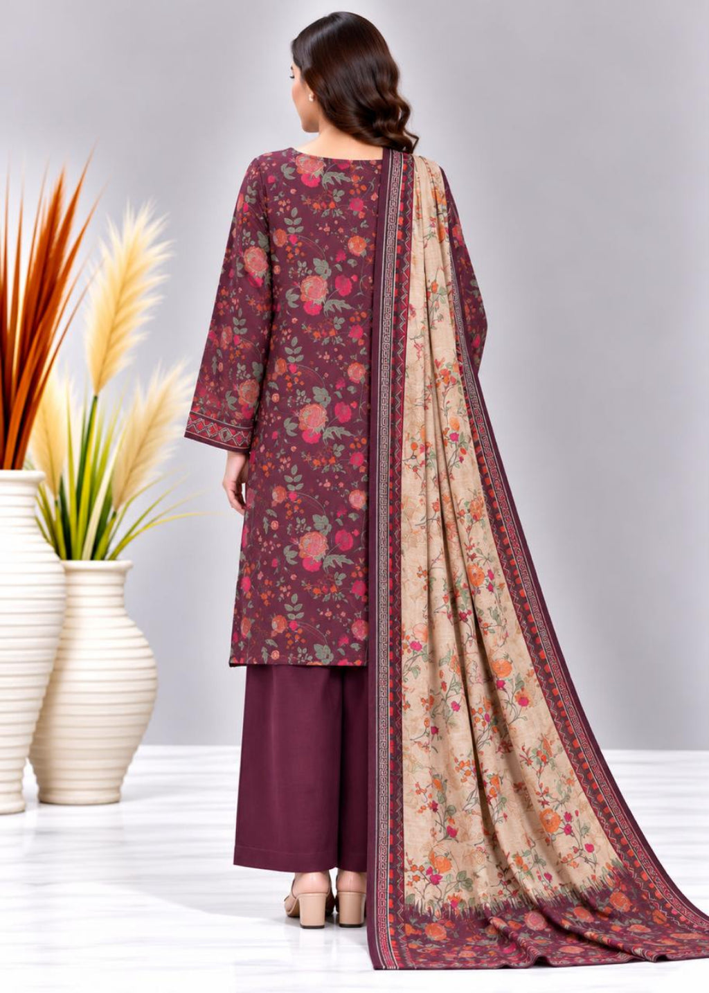 A woman shown from the back wearing a floral printed salwar kameez suit with a matching dupatta. The kurta and trousers are deep maroon, while the dupatta is beige with a floral print and a maroon border.