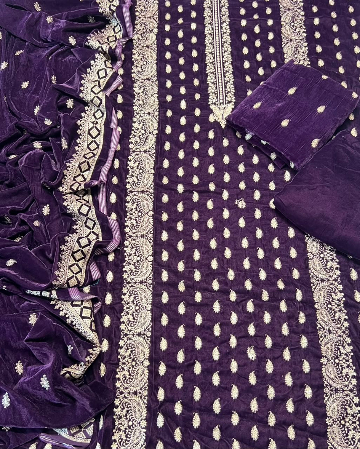 Purple velvet ethnic salwar suit material set featuring a kurta with silver mirror work embroidery, matching trousers, and a dupatta.