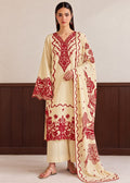 A woman models a cream-colored three-piece ethnic suit with vibrant red floral embroidery. The set includes a long-sleeved kurta with a V-neck, matching trousers, and a dupatta featuring detailed red floral and paisley patterns.