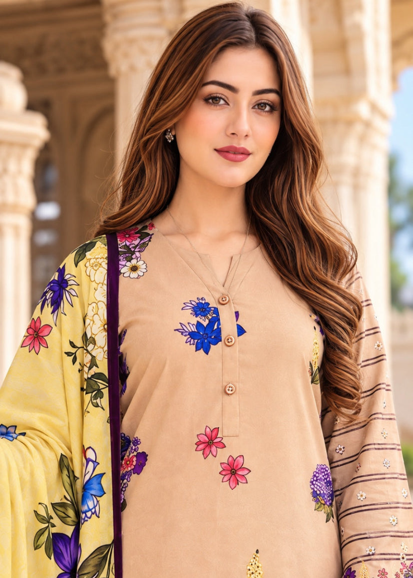 A woman modeling a beige three-piece salwar kameez suit with colorful floral embroidery, featuring a yellow dupatta with blue and pink floral patterns and striped sleeves.