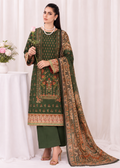 A woman models a traditional three-piece salwar kameez suit in forest green with intricate gold, orange, and red floral patterns, paired with a matching patterned dupatta, set against a soft white curtain backdrop.