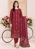 A woman models a traditional three-piece salwar kameez suit in deep maroon with intricate gold embroidery, paired with matching maroon trousers and a coordinating dupatta, posed in front of a decorative bicycle and floral arrangement.