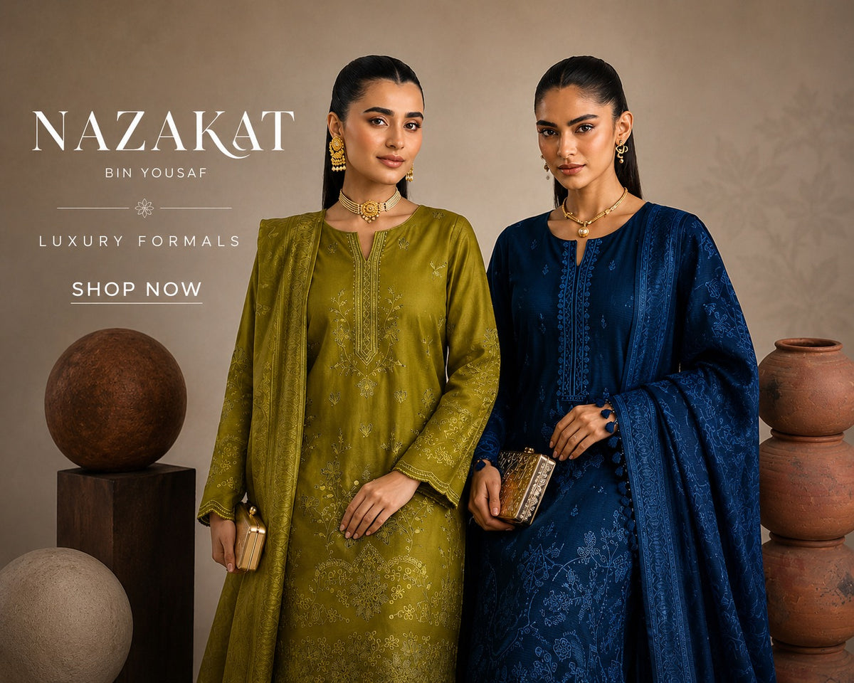 Two women modeling traditional South Asian formal outfits from Nazakat Bin Yousaf. The woman on the left wears an olive green kurta with a matching dupatta and gold embroidery, while the woman on the right wears a deep navy blue kurta with a matching dupatta and subtle floral embroidery.