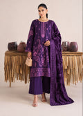 A model stands in a studio wearing a deep purple traditional outfit with matching embroidered kurta, wide-leg trousers, and a draped dupatta. The outfit features intricate lighter purple embroidery and motifs.