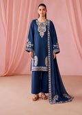 A woman models a navy blue traditional outfit with intricate silver embroidery, matching wide-leg pants, and a long draped scarf, set against a soft pink draped fabric backdrop.