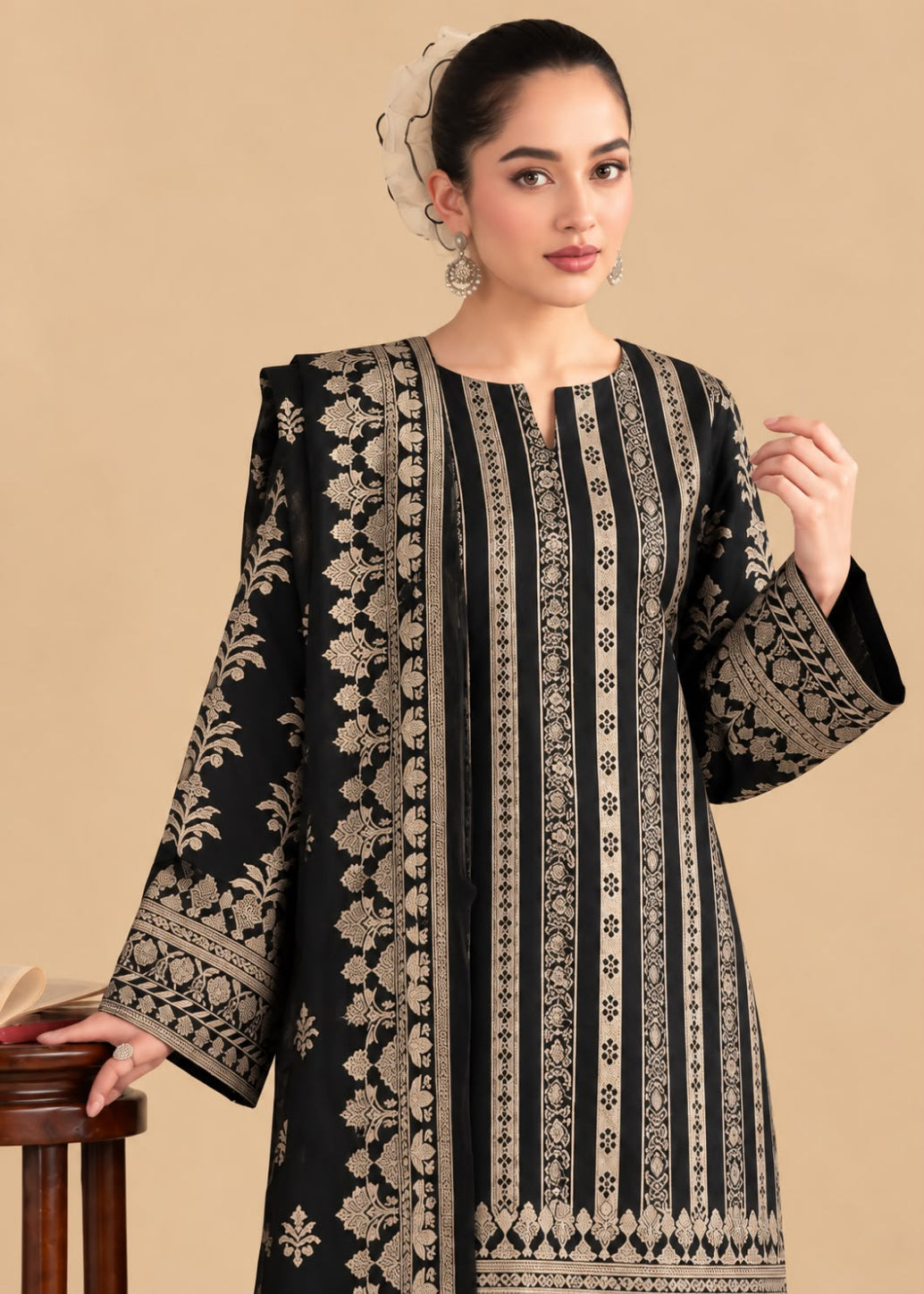 A woman models a black long kurta with intricate beige and gold vertical floral embroidery and border patterns, set against a solid beige background.