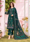 A woman models a dark green ethnic three-piece suit with floral embroidery and a matching dupatta in an outdoor garden setting with pink walls.
