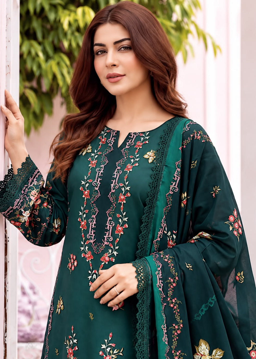 A woman models a dark green ethnic salwar kameez suit with floral embroidery and lace details, featuring a matching sheer dupatta.