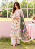 A woman models a traditional three-piece salwar kameez suit set in an outdoor garden setting. The set features an off-white printed kurta and wide-leg trousers with colorful floral motifs, paired with a matching olive green printed dupatta.
