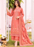 A woman models a peach-colored traditional South Asian salwar kameez suit with intricate embroidery and a matching dupatta, set against a soft pink and white garden backdrop.
