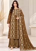A woman models a traditional Indian salwar kameez suit in brown velvet with beige floral embroidery, featuring a matching dupatta, in a bright, modern indoor setting.